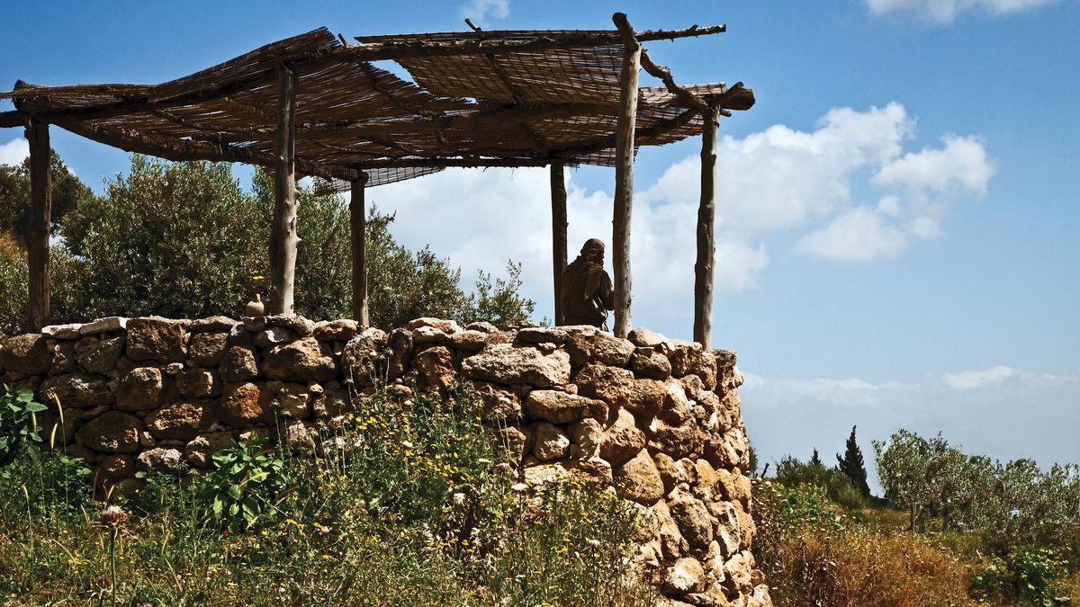An ancient stone watchtower with a shaded lookout above a hillside