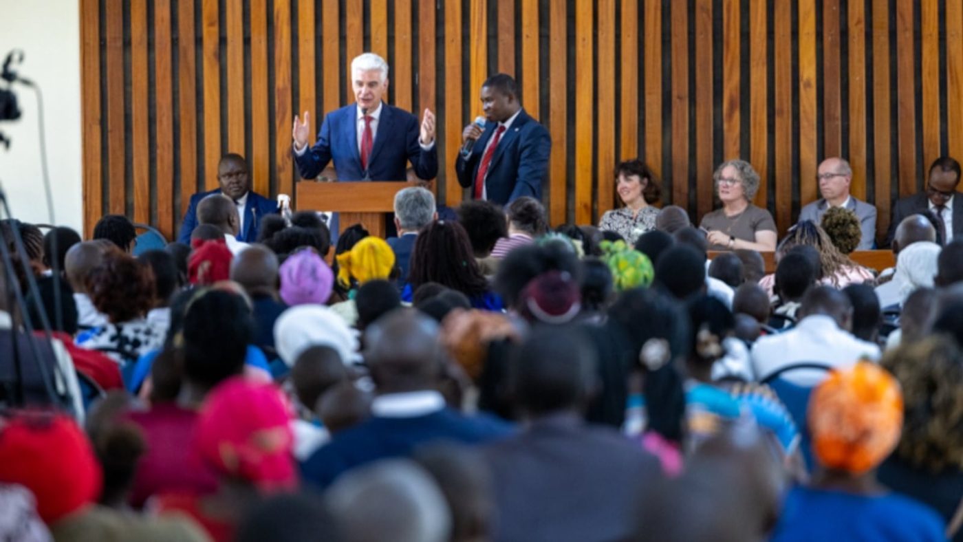 Elder Gérald Caussé speaking at a pulpit to a large congregation at a stake conference in Kyulu, Kenya