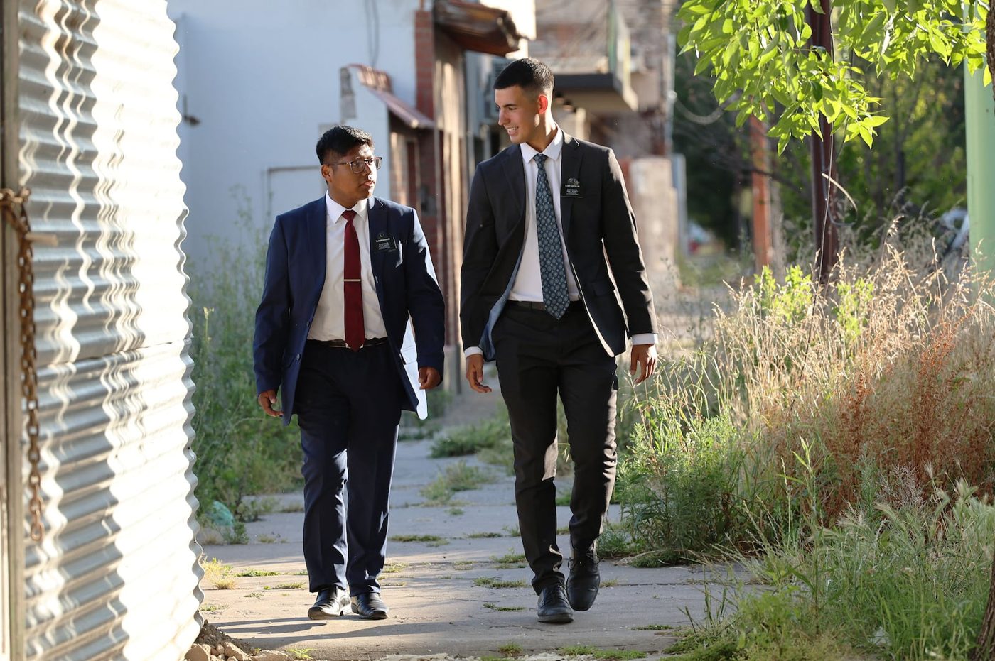 Two young elders in white shirts and ties walking down a street in Bahia Blanca, Argentina